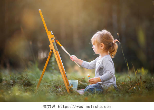 在秋天的公园画画的小女孩